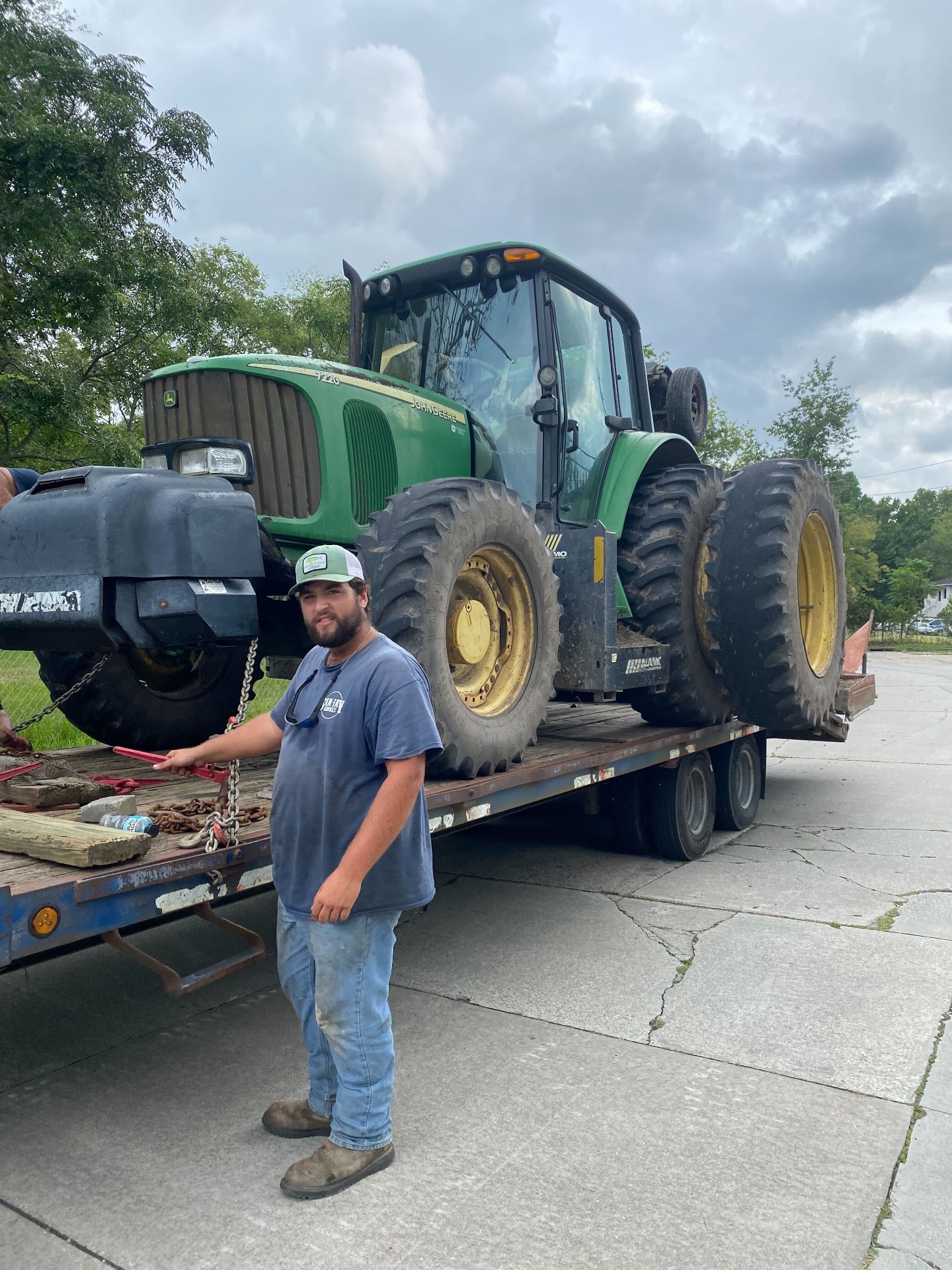 Sam-Jay crew member with John Deere tractor loaded for transport