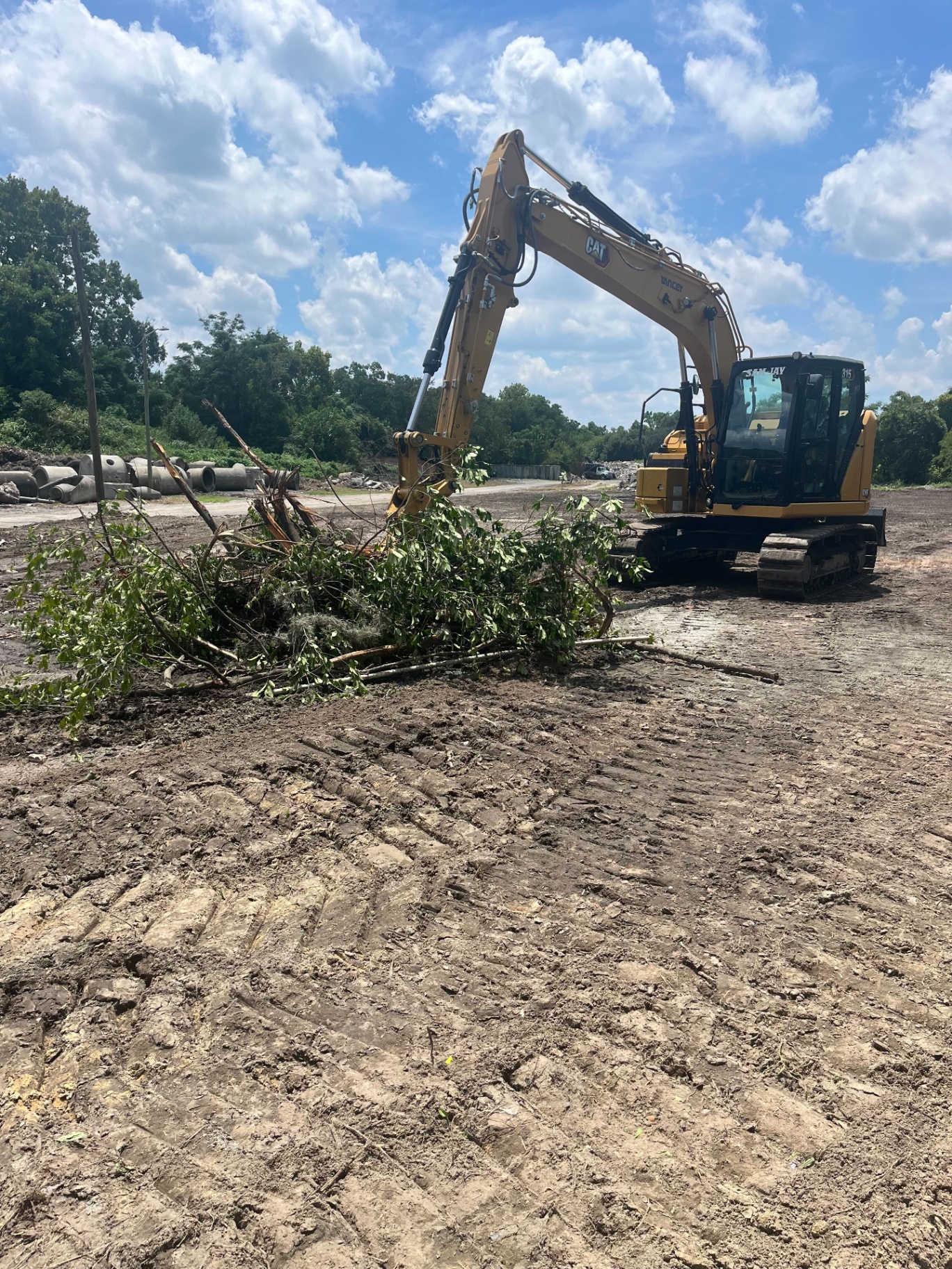 Sam-Jay CAT excavator clearing land on a job site